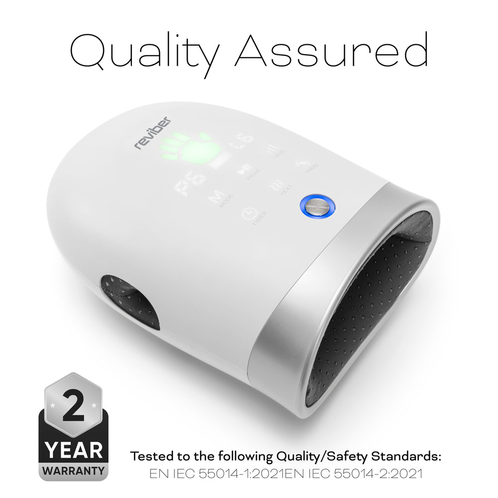 White Reviber Hand Spa Massager with Heat & Finger Stretch, featuring a digital display and labeled Quality Assured. Designed for deep tissue massage with adjustable speed, it displays a 2-year warranty badge and notes compliance with international quality and safety standards at the bottom.