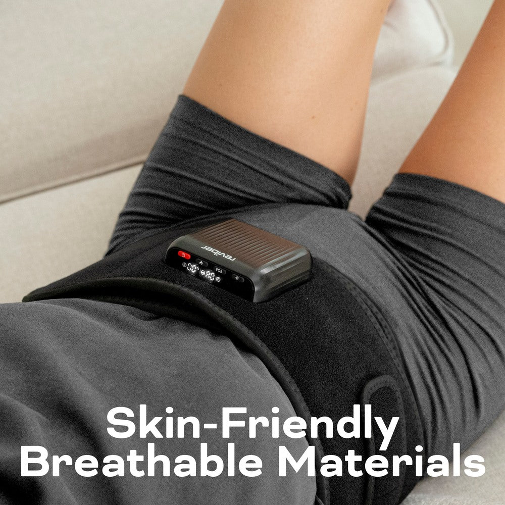 A person wears the Reviber Zen Physio Back Therapy Belt by Reviber, a black support wrap with a small electronic device and infrared light. The text on the image states, “Skin-Friendly Breathable Materials.”.