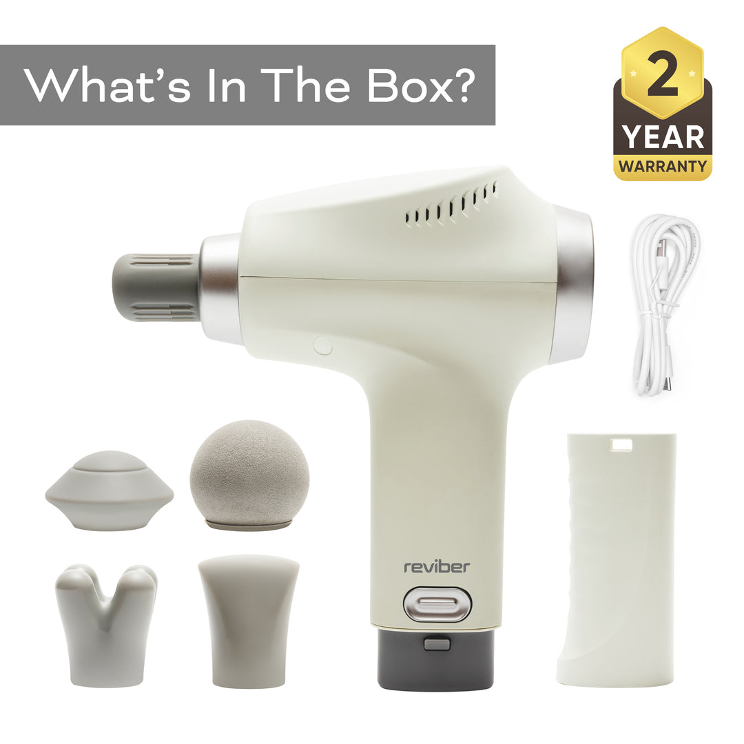 Reviber Deep Tissue Percussion Massage Gun with Long Reach Handle, five interchangeable heads, adjustable speeds, charging cable, and two-year warranty badge. “What’s In The Box?” appears above; Reviber branding featured on the device.