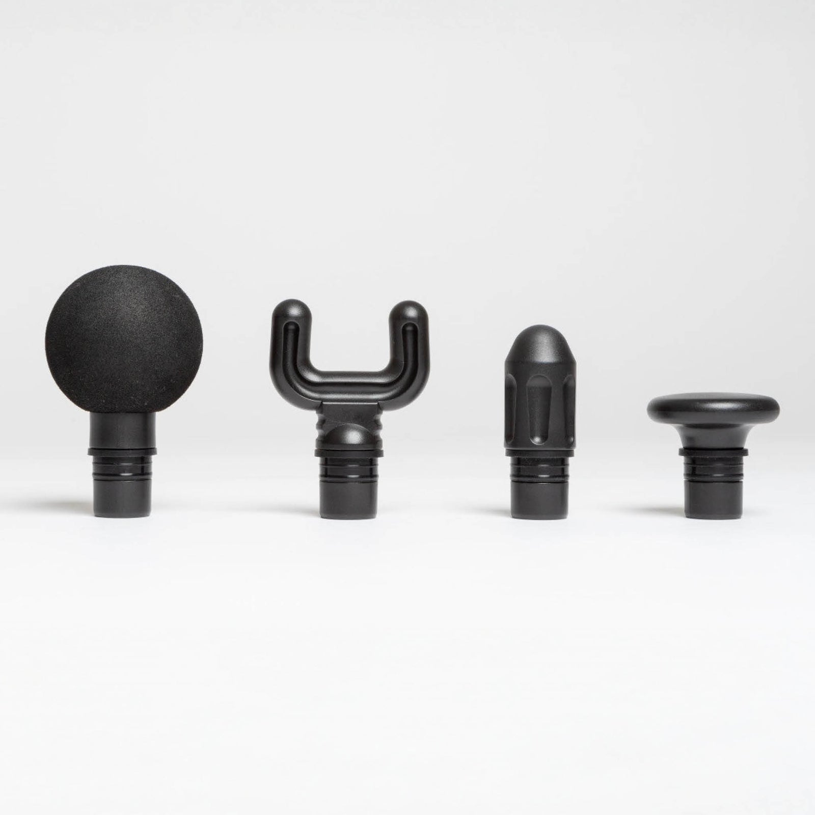 Four unique attachments for the Reviber Mini Massage Gun With Heat Therapy by Reviber—round, forked, bullet, and flat head—are lined up side by side on a white background, designed for targeted deep tissue massage.